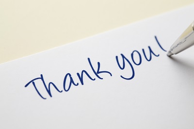 A handwritten "thank you" with the tip of the pen showing as well.